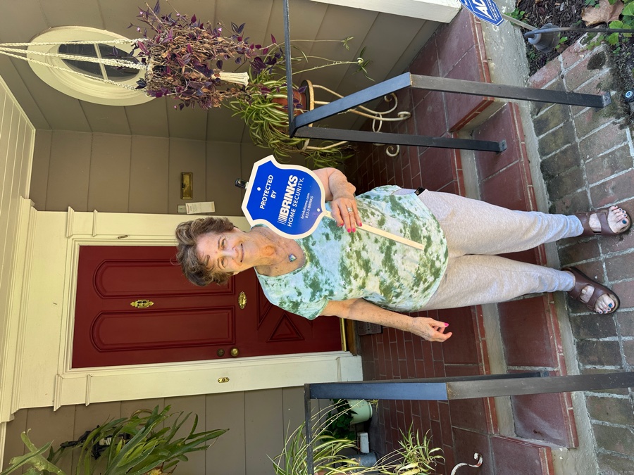 Homeowner with Brinks Home security yard sign