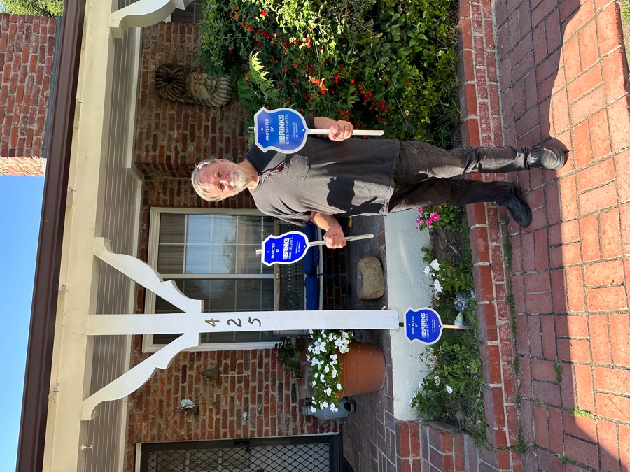 Homeowner with Brinks Home security yard sign