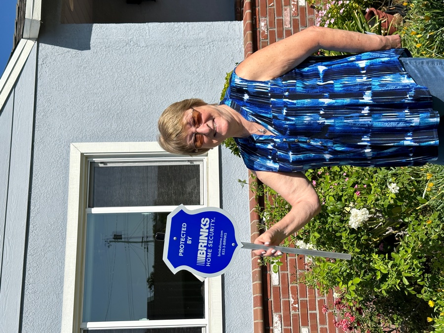 Homeowner with Brinks Home security yard sign