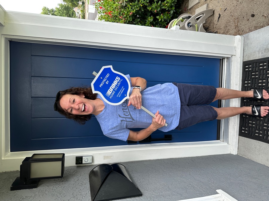 Homeowner with Brinks Home security yard sign