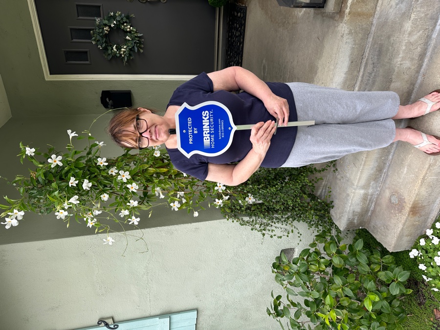 Homeowner with Brinks Home security yard sign