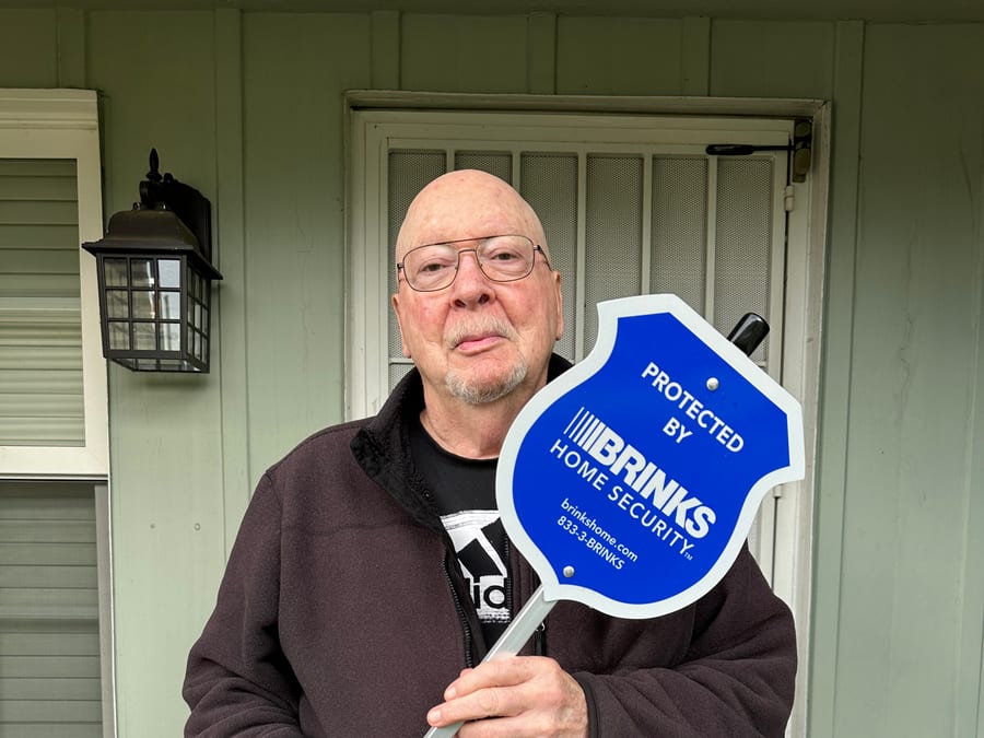 Homeowner with Brinks Home security yard sign