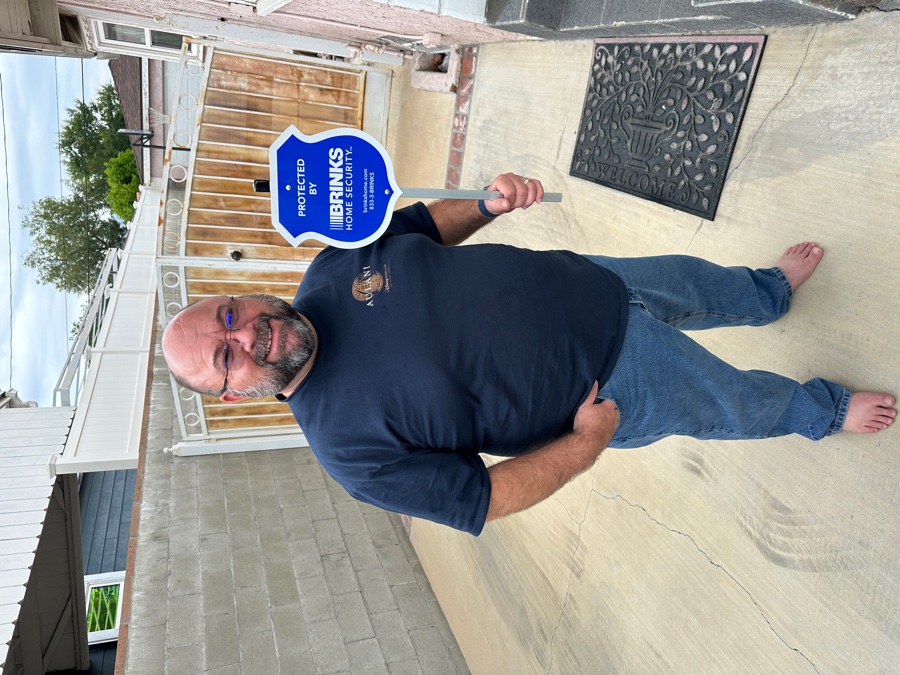 Homeowner with Brinks Home security yard sign